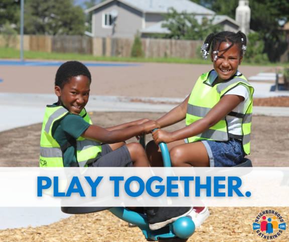 Two children in safety vests play on a piece of playground equipment in a neighborhood park.