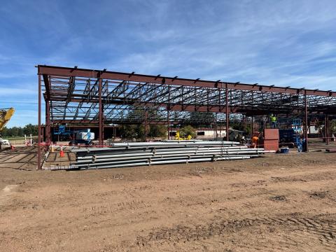 Work on the senior center renovation has progressed to a steel building frame. Construction equipment and workers are on-site.