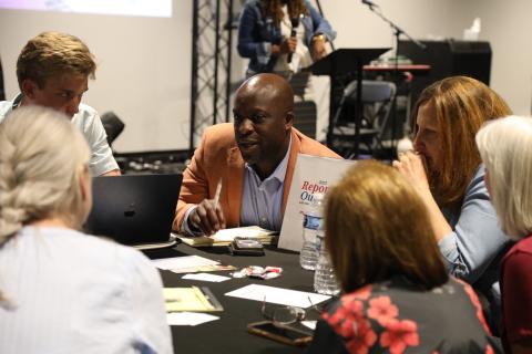 Mayor Yemi engages with residents at a table at the first Report Out Community Tour stop