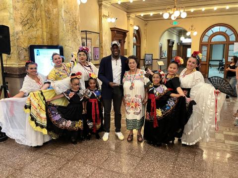 Mayor Yemi stands with community members and Connie Benavidez as he presents her with the Spirit of Colorado Springs Award
