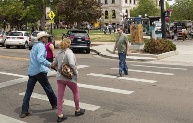 Pedestrians crossing a street in downtown Colorado Springs.