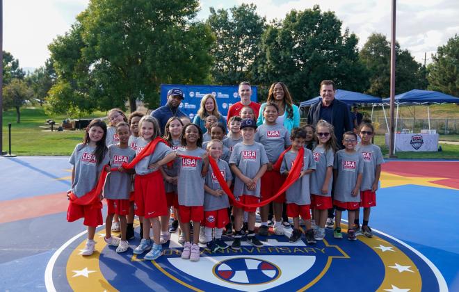 Kids pose for a picture at a ribbon cutting for new basketball courts at the Hillside Community Center