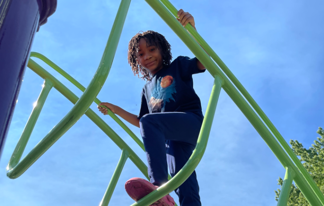 A child climbs high on a playground