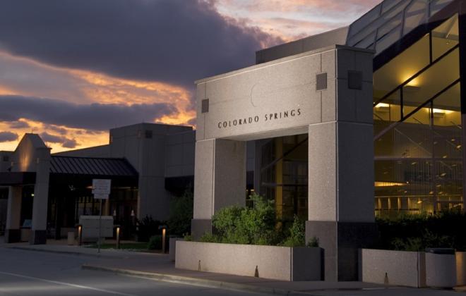 Colorado Springs Airport at dusk with beautiful purple and orange sunset and Pikes Peak in the background