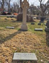 Sandstone Celtic cross headstone above a Carrington family grave.
