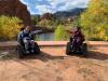 Two TRP participants take a photo in red rock canyon on their accessible trail chairs.