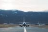 A plane on a runway at Colorado Springs Airport. The Front Range is visible in the background.